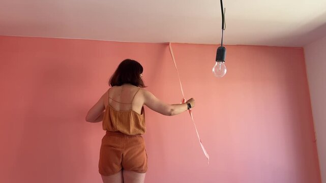 Woman paints walls in her home