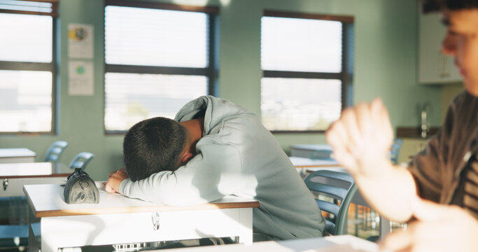 School, tired and student sleeping in classroom bored from lesson, learning and studying at desk. People, college and teen boy with fatigue, burnout or exhausted nap for test, exam or education