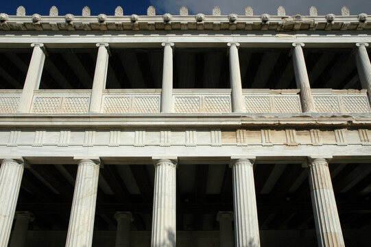 The majestic Stoa of Attalos stands in the Ancient Agora of Athens with its reconstructed marble columns and classic Greek architecture under a blue sky