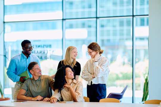 Group of happy multiracial business people discussing work during a meeting, showing teamwork and positive corporate culture