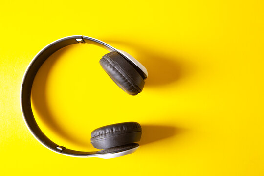 Headphones on a yellow background. Flat lay, top view.