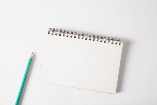 Notepad and pencil on a white background. View from above.