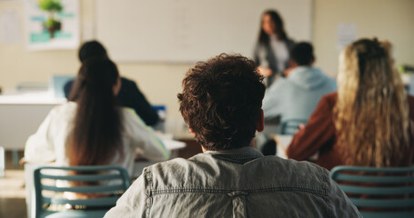Learning, teenager or students with teacher in classroom, education or listen for lesson understanding. Lecture, curriculum or people with educator for academic development, project info or knowledge © peopleimages.com
