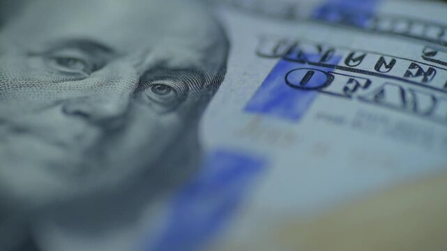 Security stripe hundred dollar bill closeup, investigative light emphasizes blue ribbon and microprint, subtle camera glide, crisp fiber detail, clinical analytical mood