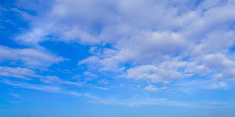 Naklejka premium Dramatic White Cumulus Clouds Across Vibrant Blue Sky Creating a Scenic Natural Cloudscape