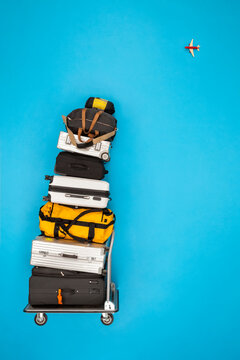 Stacked luggage and plane flying in the sky