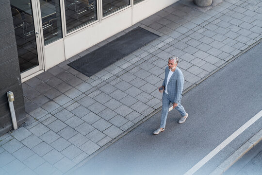 Top view of mature businessman walking on a road
