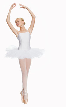 Young ballerina (14-15) standing on pointe in toe shoes,, portrait