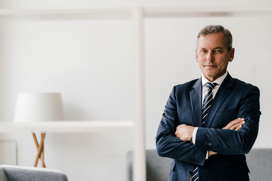 Portrait of mature businessman with arms crossed in his office