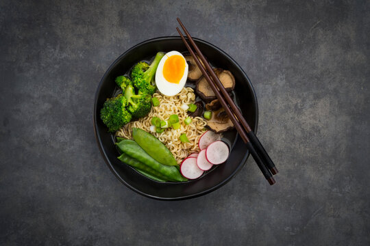Ramen soup with egg, sugar peas, broccoli, noodles, shitake mushroom and red radish