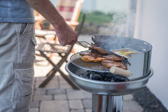 Man grilling beef on his terrace
