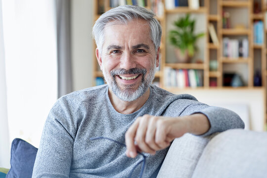 Portrait of smiling mature man sitting on couch at home