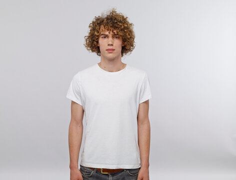 Portrait of young man with curly blond hair wearing white t-shirt