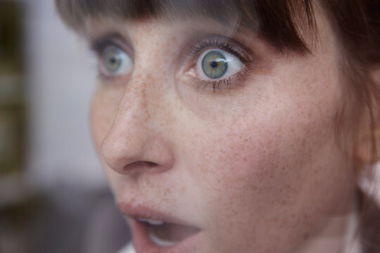 Frightened woman behind window