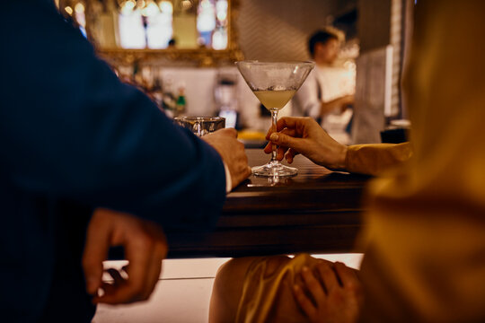 Close-up of elegant couple having a drink at the counter in a bar