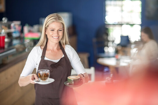 Waitress serving coffee and tea in a cafe