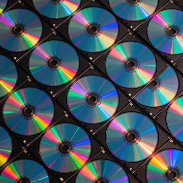 Vibrant Holographic CD ROMs Stacked in a Grid Pattern, Reflecting Rainbow Colors with a Modern, Technological Aesthetic, premium commercial stock image featuring modern professional visual compo siyam