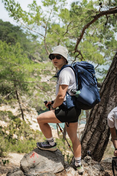 Young woman hiking on a rocky forest trail