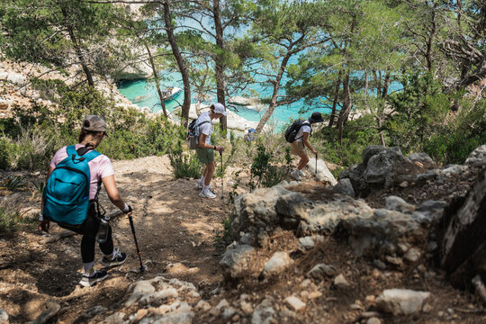Young friends hike down a steep coastal path
