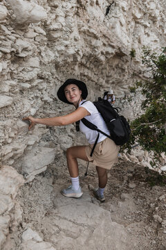 Woman smiles while hiking up a rocky trail