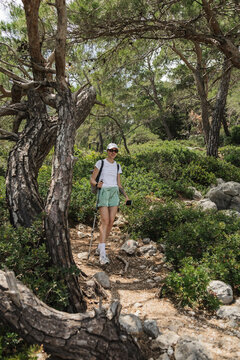Young woman hiking on a sunny forest trail