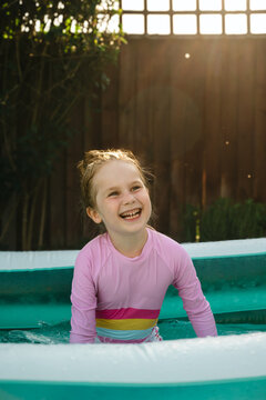 Young child playing in inflatable backyard pool
