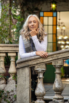 Mature woman in autumn clothes inside rustic house