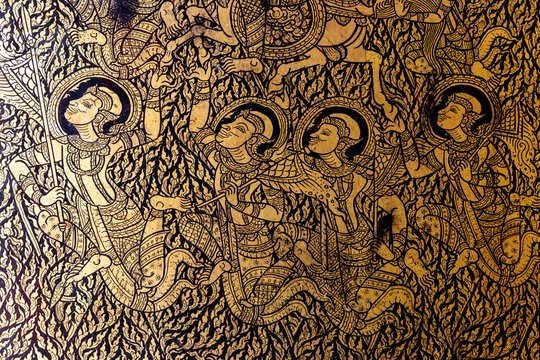 Traditional Thai gold leaf lacquer art depicting celestial beings on a black background.