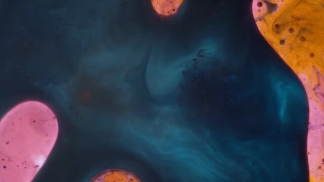 Deep blue and pink fluid ink creates organic cell patterns in this artistic experiment. A tranquil and relaxing visual for scientific concepts and laboratory research, captured in macro detail.