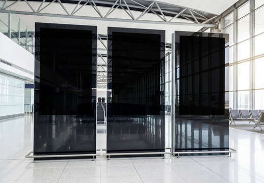 Three vertical billboards in bright clean airport interior Mockup. Generative ai