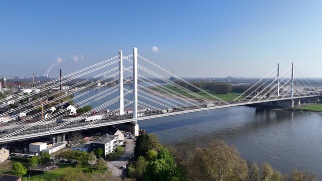 Broad circular aerial flight around the full bridge structure, emphasizing the bridge span, pylons, and traffic.