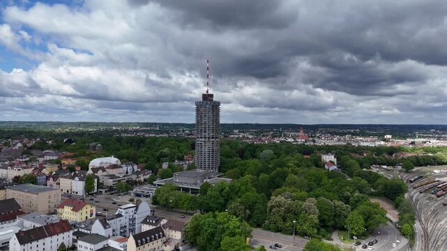 Drone perspective toward Augsburg Hotelturm with congress center and surrounding parkland.