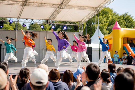 Children performing colorful dance on outdoor festival stage