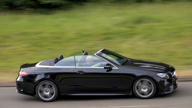 Milton Keynes,Bucks,UK - May 28th: 2020 black Mercedes Benz e 300 amg line open top car driving on a British road