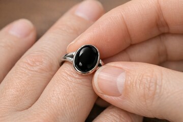 Fototapeta premium A person is holding a ring featuring a black stone