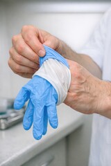 Fototapeta premium A person wearing a white shirt and blue gloves, possibly for work or a specific task