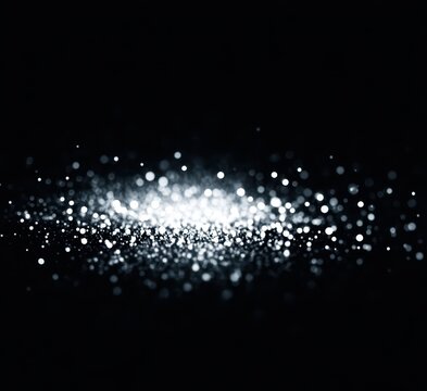 Abstract background featuring shimmering particles on a black backdrop.