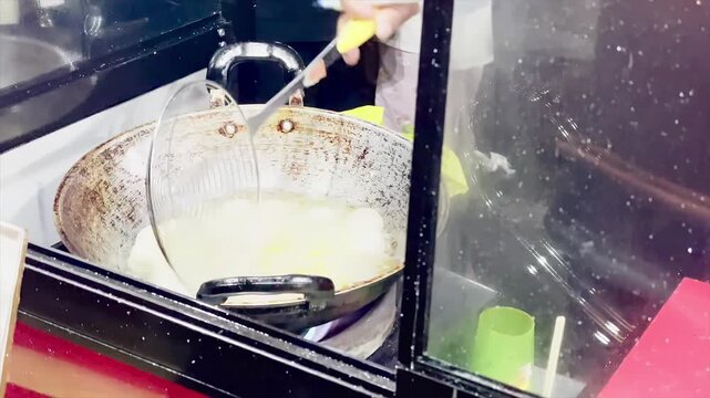Frying indonesian street food cimol in a large wok with hot oil