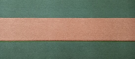 Fototapeta premium Brown ribbon on dark green fabric background