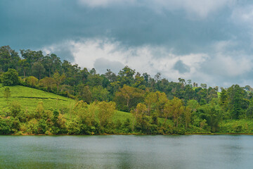 Fototapeta premium Lush green hills slope gently toward calm waters