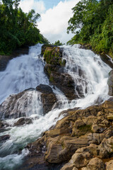 Obraz premium Powerful waterfall cascades over mossy rocks