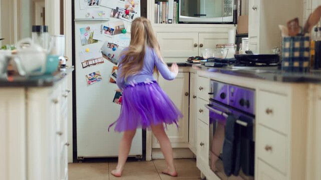 Back, dance or child with energy in kitchen for physical development, practice steps or fun in tutu. Costume, girl kid and moving to music in home for learning rhythm, creative performance and growth