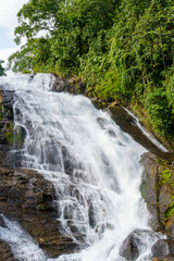 Obraz premium Water cascades over mossy stones, rushing down a rocky cliff