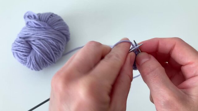 A woman knits with knitting needles, creating a warm woolen thing. An atmosphere of flow and inspiration, when simple tools and human hands turn thread into art