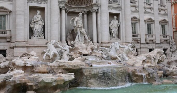 A stunning slow-motion video of an ornate fountain set against a beautiful architectural backdrop. The footage captures sparkling water droplets, graceful cascades, and intricate stonework