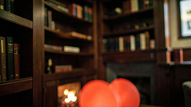 Fireside library ambiance with dark wood shelves and glowing red orbs