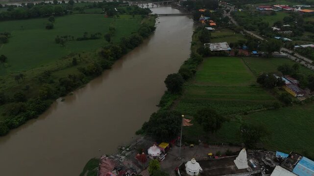 High-angle drone shot capturing the scenic Shipra Nadi flowing through green landscapes in Ujjain.