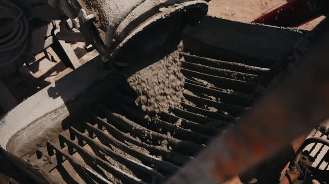 Concrete mixture unloading into aggregate screening machine close up