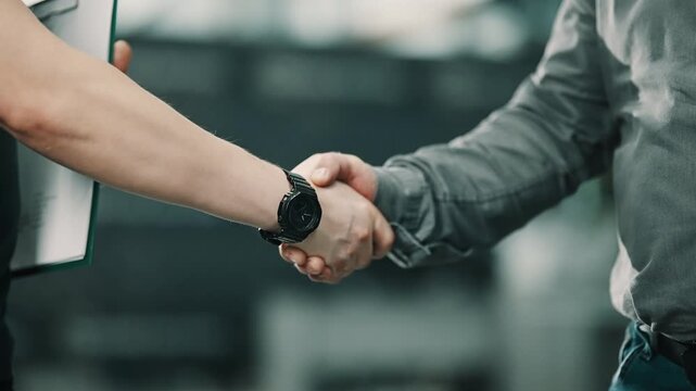 Close-up sequence of two professionals concluding a meeting with a confident handshake, one holding a clipboard, symbolizing agreement, partnership, and business trust