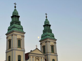 Fototapeta premium Budapest church bell towers with moon illuminating evening sky